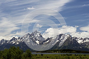 Snow capped mountains above a clear blue lake in Yellowstone.