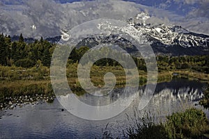 Snow capped mountains and a clear blue lake in the Grand Tetons.