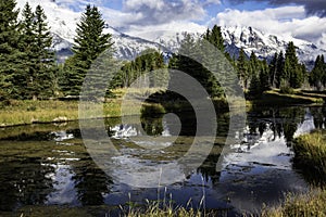 Snow capped mountains and a clear blue lake in the Grand Tetons.