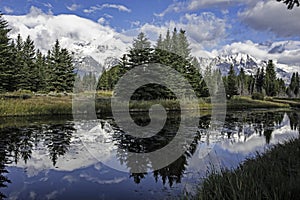 Snow capped mountains and a clear blue lake in the Grand Tetons.