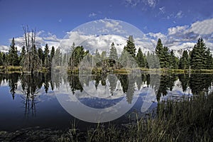 Snow capped mountains and a clear blue lake in the Grand Tetons.