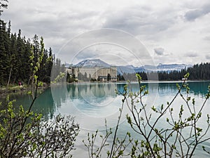Snow capped mountains and clear lake with lodge