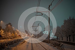 Snow capped railway track or railroad covered with snow during night time