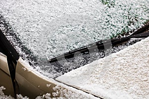 Snow on car, windshield wipers with snow close up