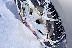 Snow chain on a wheel in deep snow in winter