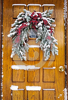 Snow on Christmas pine bough on door