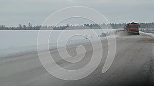 Snow-cleaning machines clean the winter road in slow motion