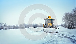 Snow clearing. Tractor clears the way after heavy snowfall photo