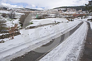 Snow covered access road to a mountain village photo