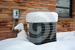 Snow Covered Air Conditioner on a Cold Winter Day photo