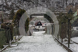 Snow covered alley between the houses leading down the hill