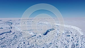 Snow covered antarctic surface aerial view flight.