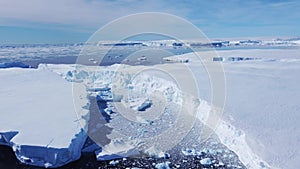 Snow covered antarctic surface aerial view flight.