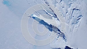 Snow covered antarctic surface aerial view flight.