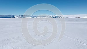 Snow covered antarctic surface aerial view flight.