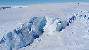 Snow covered antarctic surface aerial view flight.