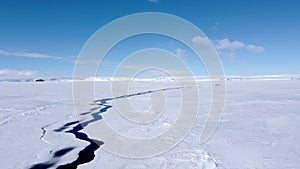 Snow covered antarctic surface aerial view flight.