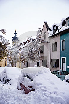 A snow-covered avenue and parked cars on a snow-covered street