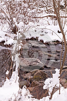 Snow covered banks along Nine Mile Run with rocks in the stream on a winter day, Pittsburgh, Pennsylvania, USA