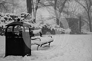 A snow-covered bench in the park. A bench covered with snow by t