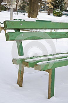 Snow covered bench in a park