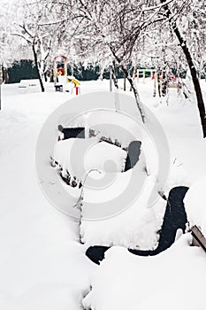 snow-covered benches in public urban garden