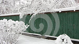 snow-covered boardwalk old green fence. Countryside gloomy winter day