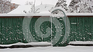 snow-covered boardwalk old green fence. Countryside gloomy winter day