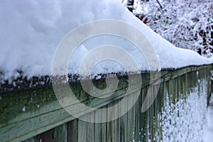 snow-covered boardwalk old green fence. Countryside gloomy winter day