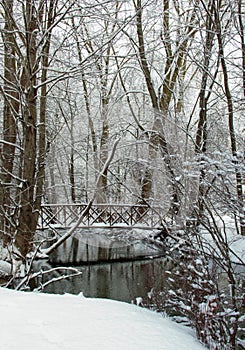 Snow covered bridge over creek