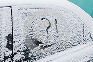 Snow covered car with question and exclamation mark