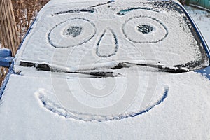 Snow-covered car with smiley