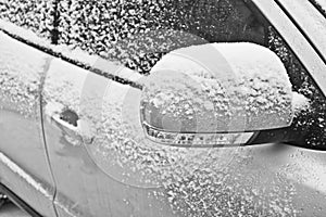 Snow covered car. Snow-covered side mirror of a avto. Winter problems with the car