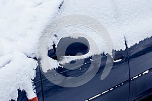 Snow-covered car after a snowfall. Deteriorating weather conditions in winter