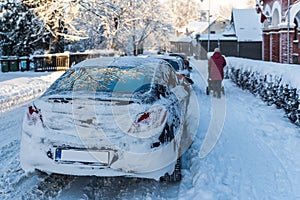 A snow-covered car was parked on the street