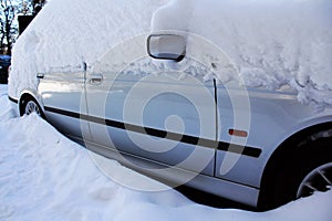 Snow-covered car by winter