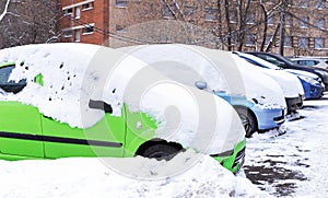 Snow-covered cars. Parked cars buried under snow.