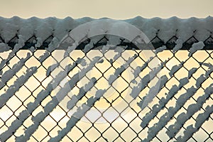 Snow covered chain link fence in winter