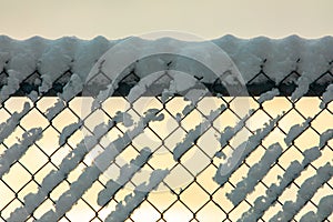 Snow covered chain link fence in winter