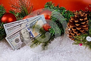 Snow covered christmas decoration with tree branch on the USA 100 dollar bills