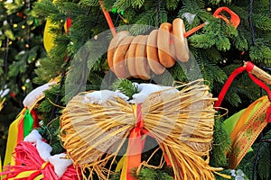 Snow-covered christmas tree decorated with straw toys and bagels