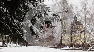 Snow-covered church, snowdrifts, pine in the snow