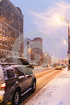 Snow-covered city road in winter evening