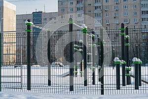 Snow-covered complex of sports simulators in the courtyard of a school in a residential area of the Moscow region