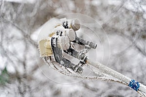 Snow-covered converter of a satellite dish over the white background. Sattelite converter in hoarfrost. Close-up.