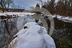 Snow covered creek bed on Mount vernon creek in Donald County park with watercress in the fresh spring water.