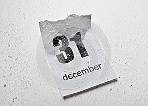 Snow-covered crumpled sheet of tear-off calendar