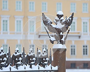 Snow-covered doubleheaded eagle on a decorative fence