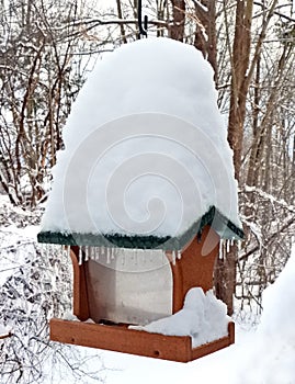 Snow covered empty birdfeeder waiting to be refilled