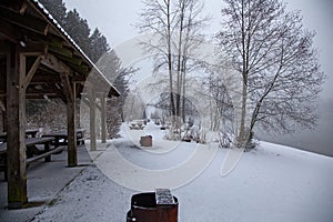 Snow covered firepits and picnic table